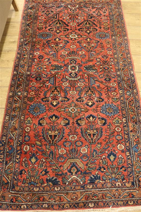 A Persian coral ground rug, 6ft 10in by 3ft 7in.